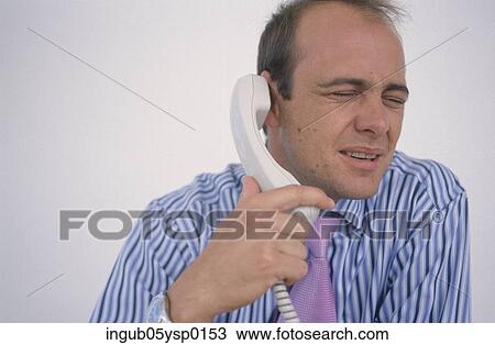 Stock Image - Mid-adult man talking on a telephone. Fotosearch