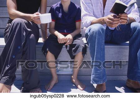 Midsection view of a couple sitting with their son View Large Photo Image Stock Photo - Midsection view of a couple sitting with their son. Fotosearch
