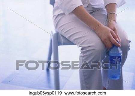 Midsection view of a woman holding a bottle of water View Large Photo Image Stock Photo - Midsection view of a woman holding a bottle of water. Fotosearch