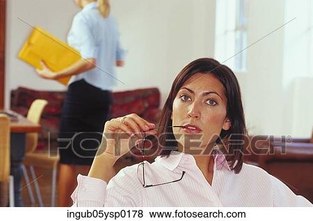 Portrait of a businesswoman biting the shaft of her eyeglasses View Large Photo Image Stock Photo - Portrait of a businesswoman biting the shaft of her eyeglasses. Fotosearch
