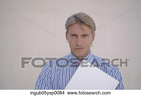 Picture - Portrait of a young man holding a file. Fotosearch
