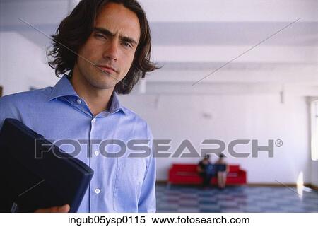 Portrait of a young man holding a laptop View Large Photo Image Stock Photography - Portrait of a young man holding a laptop. Fotosearch
