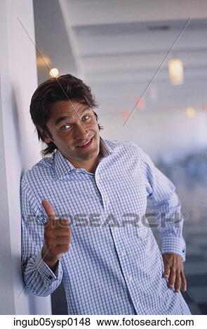 Portrait of a young man showing a thumbs up sign View Large Photo Image Stock Photo - Portrait of a young man showing a thumbs up sign. Fotosearch