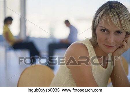 Stock Image - Portrait of a young woman sitting on a chair. Fotosearch