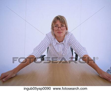 Stock Image - Portrait of a young woman sitting on a chair. Fotosearch