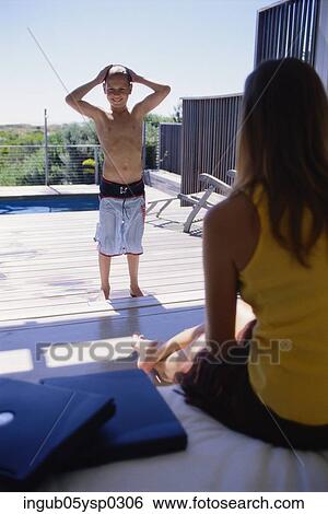 Rear view of a young woman looking at her son View Large Photo Image Stock Photograph - Rear view of a young woman looking at her son. Fotosearch