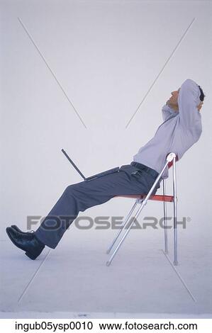 Side profile of a businessman reclining on a chair View Large Photo Image Stock Image - Side profile of a businessman reclining on a chair. Fotosearch