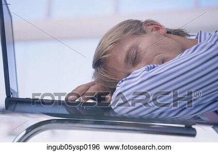 Stock Photograph - Side profile of a businessman sleeping on an office table. Fotosearch