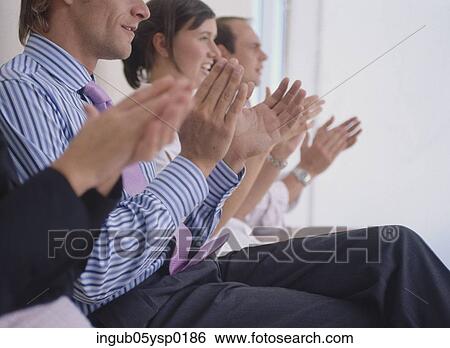 Stock Photograph - Side profile of a group of a Business executives clapping at a presentation. Fotosearch