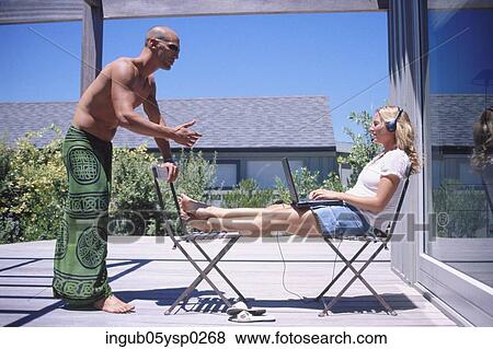 Side profile of a young couple talking outdoors View Large Photo Image Stock Photo - Side profile of a young couple talking outdoors. Fotosearch