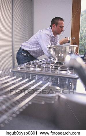 Side profile of a young man leaning on a kitchen counter View Large Photo Image Stock Image - Side profile of a young man leaning on a kitchen counter. Fotosearch