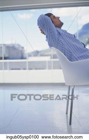 Side profile of a young man reclining on a chair View Large Photo Image Stock Image - Side profile of a young man reclining on a chair. Fotosearch