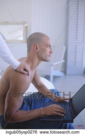 Side profile of a young man using a laptop View Large Photo Image Stock Photograph - Side profile of a young man using a laptop. Fotosearch