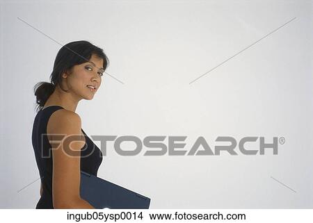 Picture - Side profile of a young woman carrying a laptop. Fotosearch