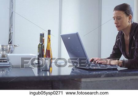 Side profile of a young woman using a laptop View Large Photo Image Stock Image - Side profile of a young woman using a laptop. Fotosearch
