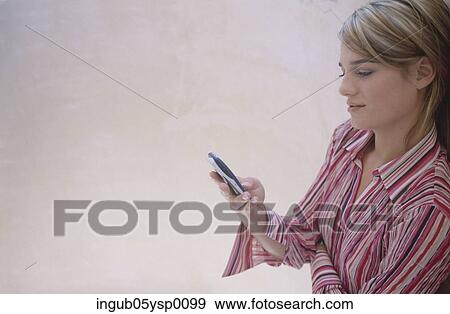 Side profile of a young woman using a mobile phone View Large Photo Image Stock Photo - Side profile of a young woman using a mobile phone. Fotosearch