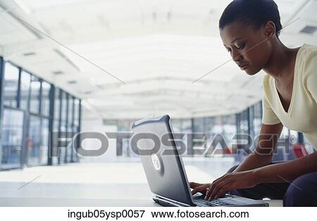 Side profile of a young woman working on a laptop View Large Photo Image Stock Photo - Side profile of a young woman working on a laptop. Fotosearch