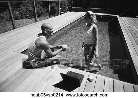 Side profile of young couple at a swimming pool View Large Photo Image Picture - Side profile of young couple at a swimming pool. Fotosearch