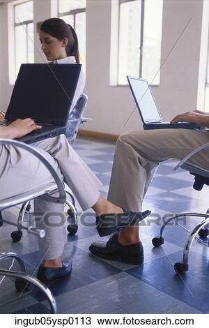Stock Image - Three people working on laptops. Fotosearch