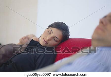 Stock Photo - Two young women and a young man sleeping on a couch. Fotosearch