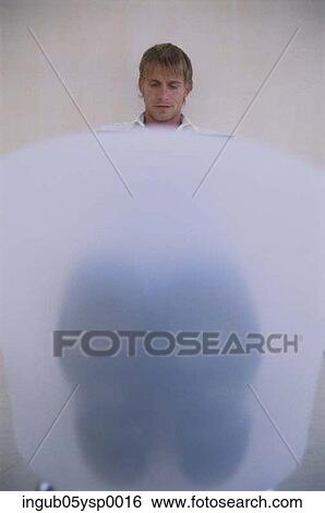Stock Photograph - Young businessman sitting and looking down. Fotosearch