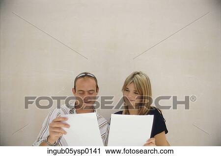 Young couple reading documents together View Large Photo Image Stock Image - Young couple reading documents together. Fotosearch