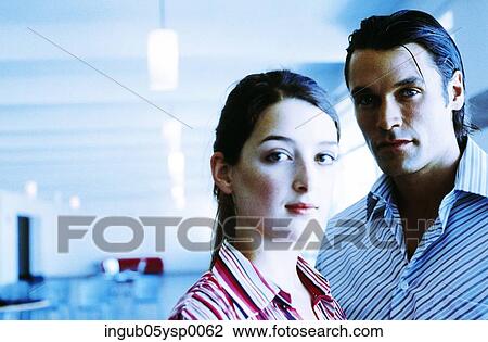 Stock Image - Young couple standing and looking at the camera. Fotosearch