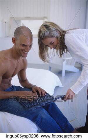 Stock Photograph - Young couple working on a laptop. Fotosearch