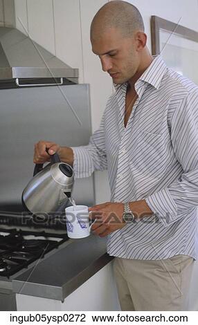 Stock Image - Young man making coffee. Fotosearch