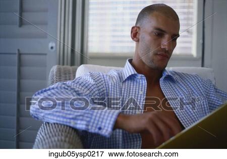 Young man sitting in a chair and reading a file View Large Photo Image Stock Photo - Young man sitting in a chair and reading a file. Fotosearch