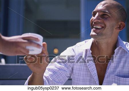 Young man taking a cup of coffee from a person's hand View Large Photo Image Stock Photo - Young man taking a cup of coffee from a person's hand. Fotosearch