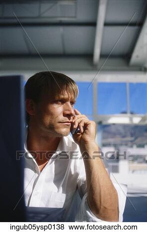 Young man talking on a mobile phone View Large Photo Image Stock Photo - Young man talking on a mobile phone. Fotosearch
