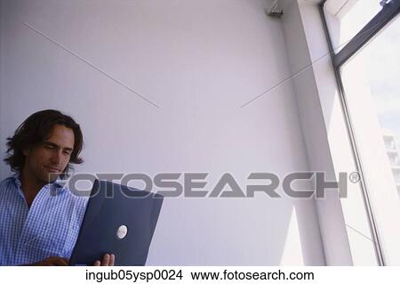 Picture - Young man working on a laptop. Fotosearch
