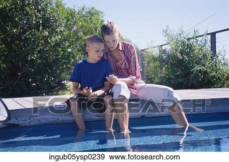 Young woman and her son sitting by a swimming pool View Large Photo Image Stock Photo - Young woman and her son sitting by a swimming pool. Fotosearch