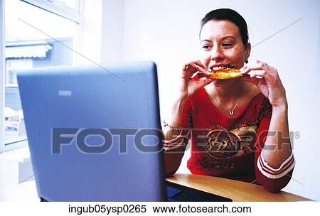 Young woman eating a snack at work View Large Photo Image Stock Photography - Young woman eating a snack at work. Fotosearch