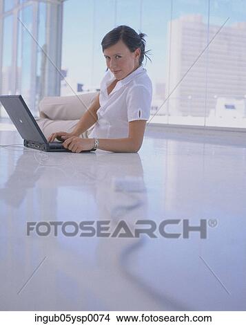 Young woman lying on the floor with a laptop View Large Photo Image Picture - Young woman lying on the floor with a laptop. Fotosearch