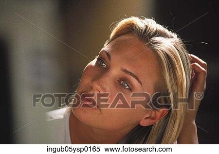 Stock Photography - Young woman running her fingers through her hair. Fotosearch
