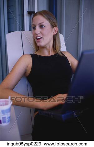 Young woman sitting with a laptop View Large Photo Image Stock Photo - Young woman sitting with a laptop. Fotosearch