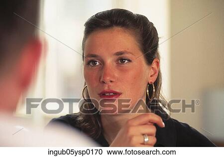 Young woman talking to a person sitting across her View Large Photo Image Stock Image - Young woman talking to a person sitting across her. Fotosearch