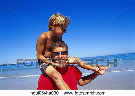 Stock Image - Close-up of a boy sitting on his father's shoulders. Fotosearch