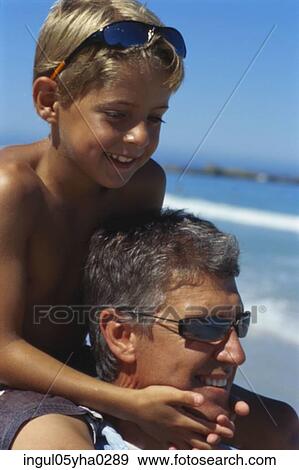 Close-up of a boy sitting on his father's shoulders View Large Photo Image Stock Photo - Close-up of a boy sitting on his father's shoulders. Fotosearch