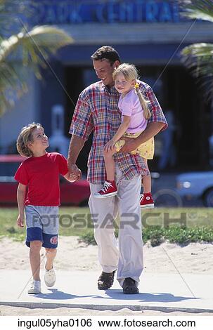 Father walking with his two daughters View Large Photo Image Stock Photograph - Father walking with his two daughters. Fotosearch