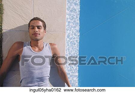 High angle view of a young man lying beside a swimming pool View Large Photo Image Stock Image - High angle view of a young man lying beside a swimming pool. Fotosearch