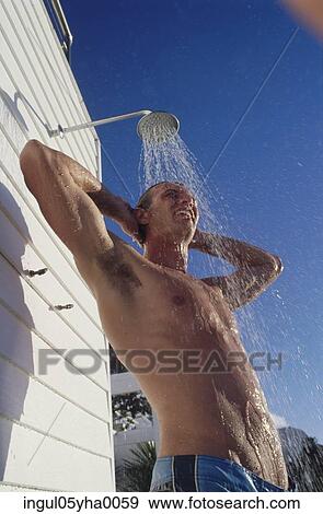 Low angle view of a young man taking a shower View Large Photo Image Stock Photo - Low angle view of a young man taking a shower. Fotosearch