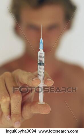 Picture - Man holding a syringe. Fotosearch