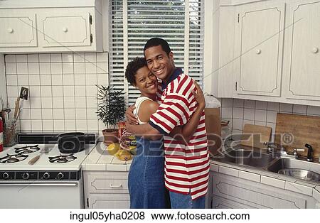 Stock Photo - Mid adult couple hugging each other. Fotosearch
