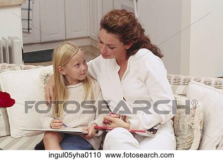 Stock Image - Mother reading a book with her daughter. Fotosearch