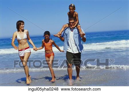 Stock Photo - Parents with their son and daughter on the beach. Fotosearch