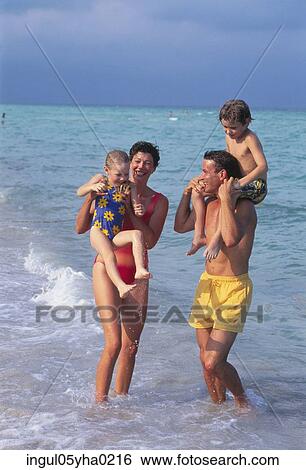 Stock Photograph - Parents with their son and daughter on the beach. Fotosearch