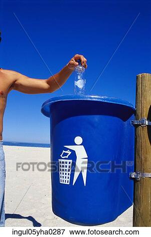 Person throwing trash into a trash bin on the beach View Large Photo Image Stock Photo - Person throwing trash into a trash bin on the beach. Fotosearch